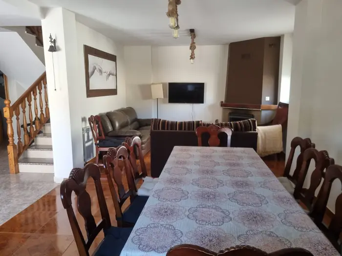 Salón comedor con mesa larga, sofás y chimenea